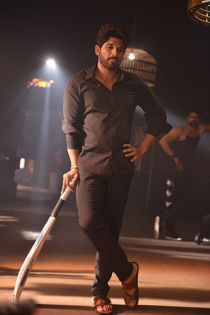 Allu Arjun in a dramatic black shirt holding a cricket bat under moody stage lighting HD phone wallpaper