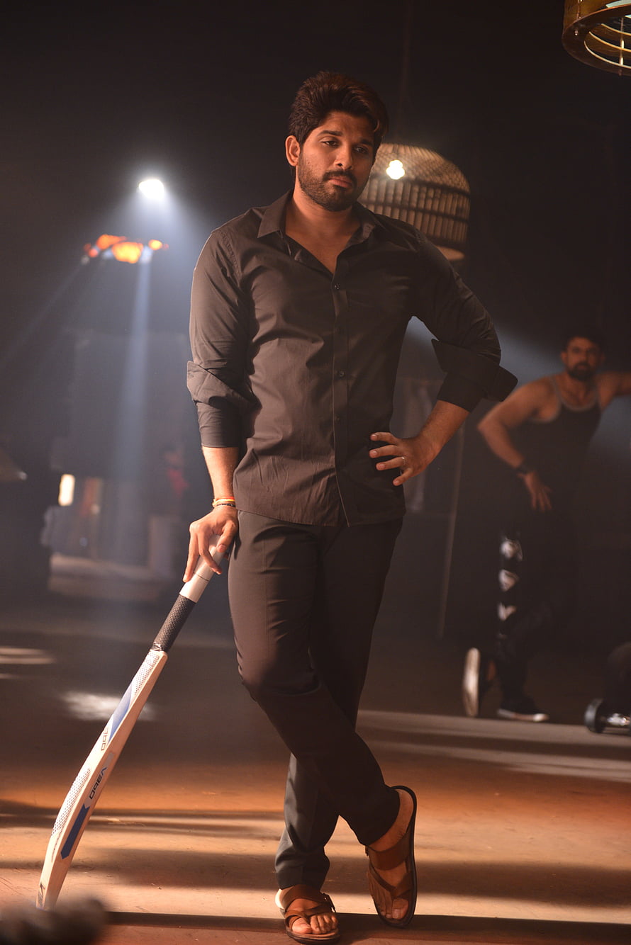 Allu Arjun in a dramatic black shirt holding a cricket bat under moody stage lighting HD phone wallpaper