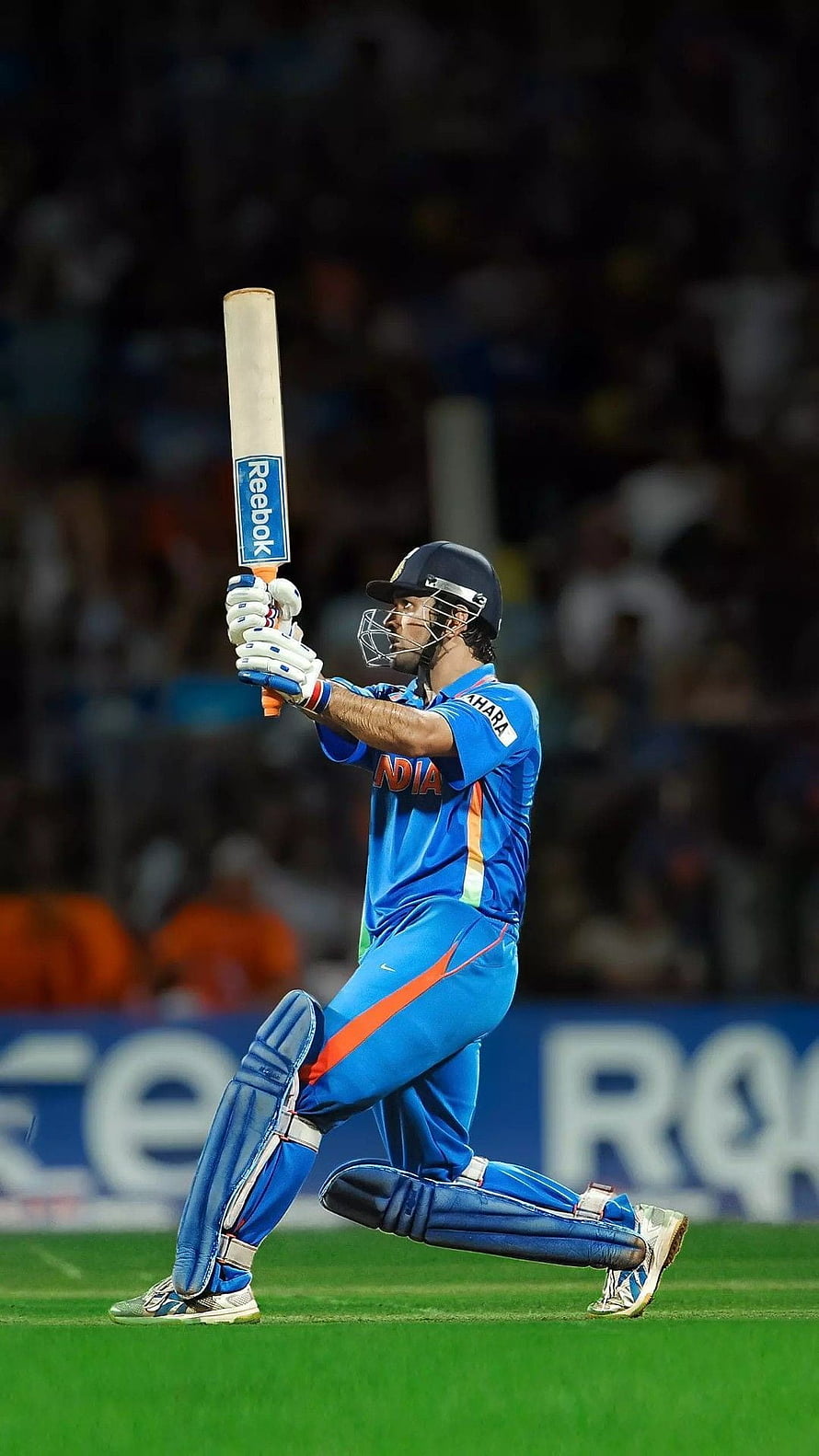 MS Dhoni in Indian cricket uniform executing a powerful batting stroke on the field HD phone wallpaper