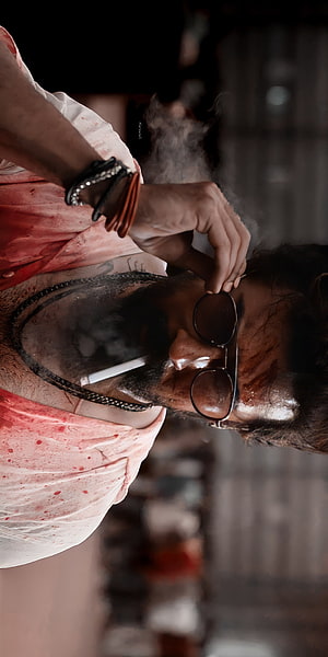 Suriya as Vikram in a gritty action scene wearing sunglasses and a blood-stained shirt HD phone wallpaper