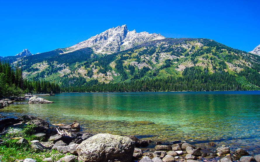 Alpine Lake with Turquoise Water and Rocky Shoreline Under a Clear Blue Sky HD wallpaper