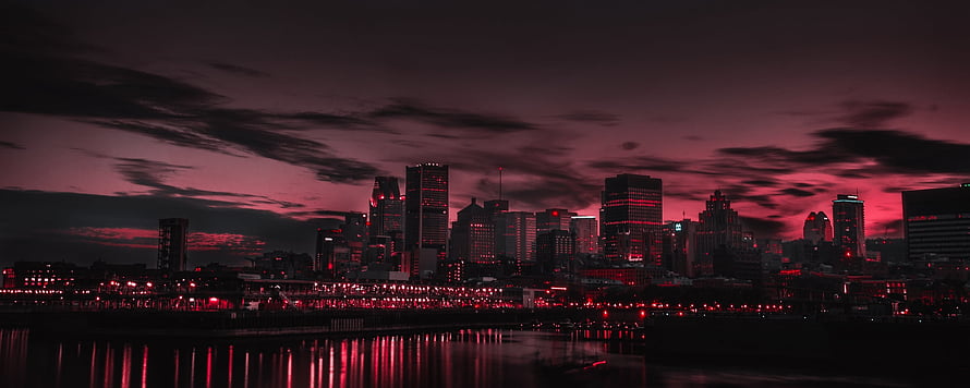 Dramatic Red Tinted City Skyline at Night with Water Reflections HD wallpaper