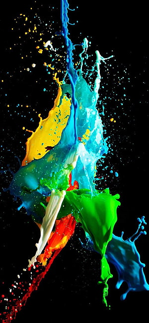 Vibrant multicolored paint splash frozen in motion against a deep black background HD phone wallpaper