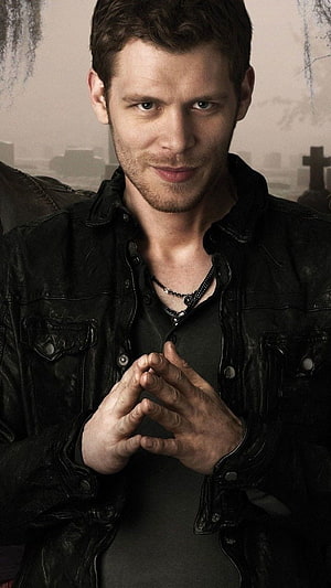 Klaus Mikaelson from The Originals in a black leather jacket with a cemetery backdrop HD phone wallpaper