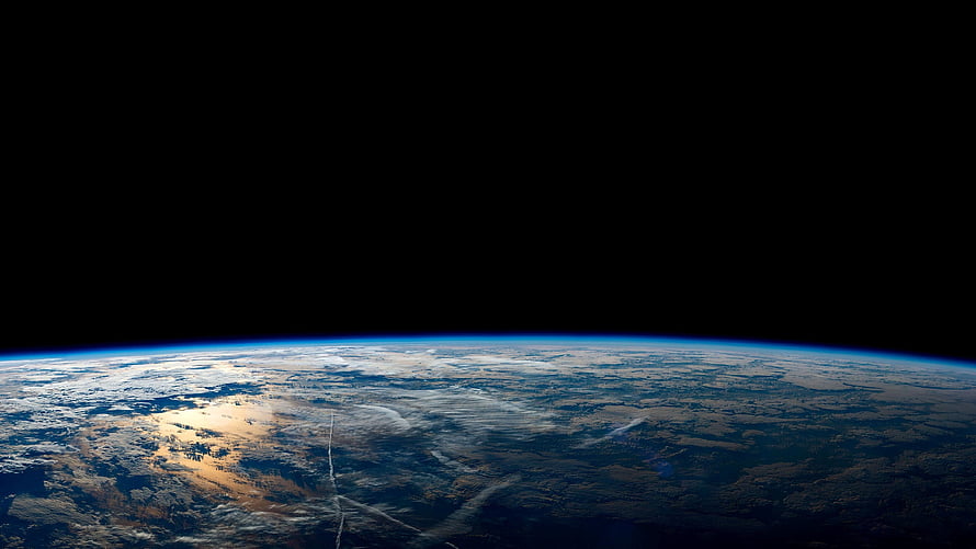 Earth Horizon From Orbit With Blue Atmosphere And Cloud Cover Against Black Space HD wallpaper