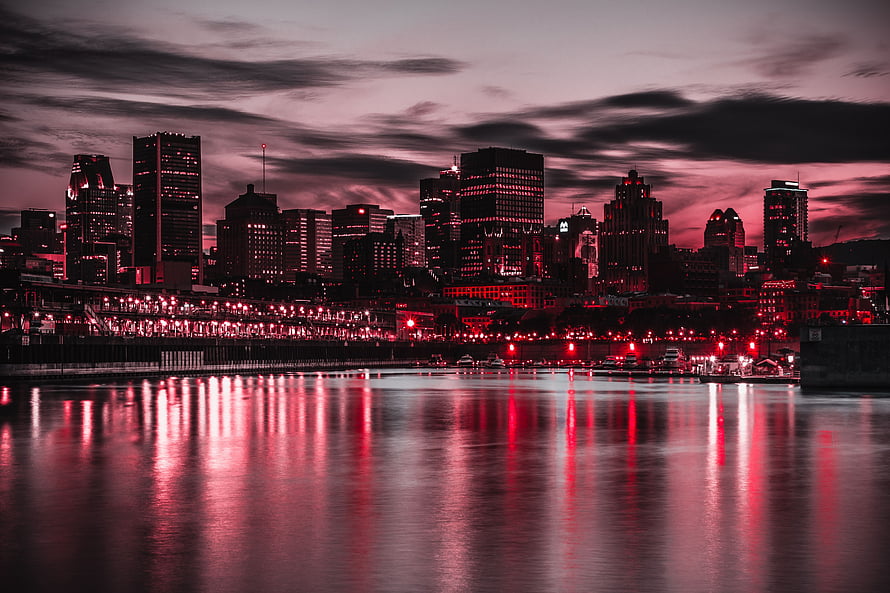 Dramatic Red Tinted City Skyline Reflected in Water at Dusk HD wallpaper