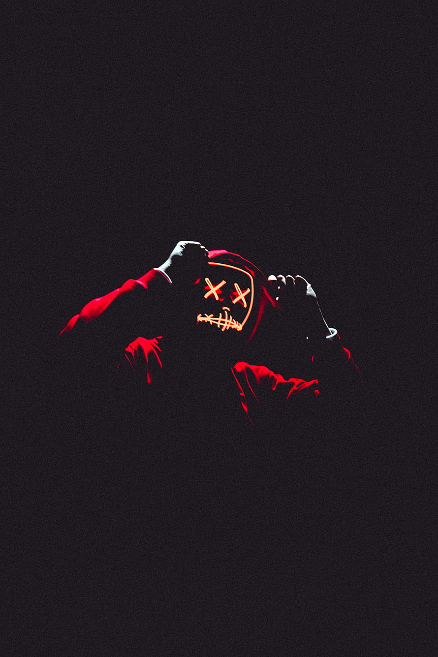Anonymous Figure in Red Hood and Glowing X-Eye Mask Against Black Background HD phone wallpaper