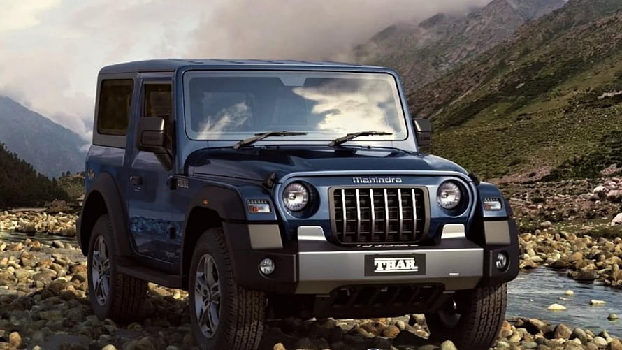 Mahindra Thar SUV parked on rocky riverbed with mountain backdrop HD wallpaper