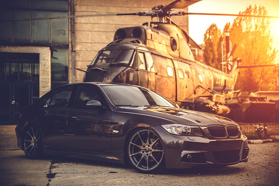 Black BMW E90 Sedan with Deep Concave Wheels Parked in Front of a Military Helicopter HD wallpaper