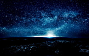 Vast Milky Way Galaxy Arching Over a Dark Rocky Horizon Under a Deep Blue Starry Night Sky HD wallpaper