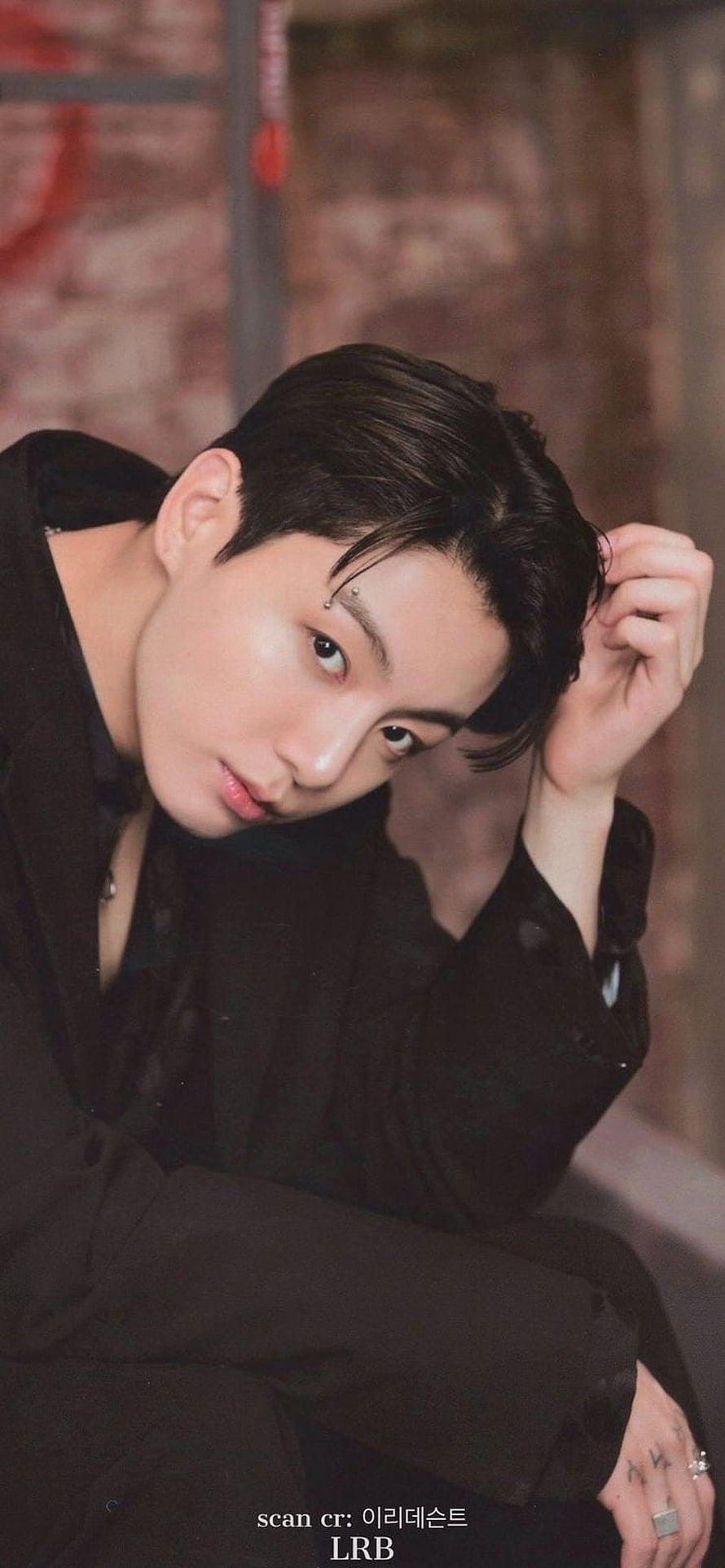 Jungkook from BTS in a moody black outfit with a brick wall backdrop HD phone wallpaper