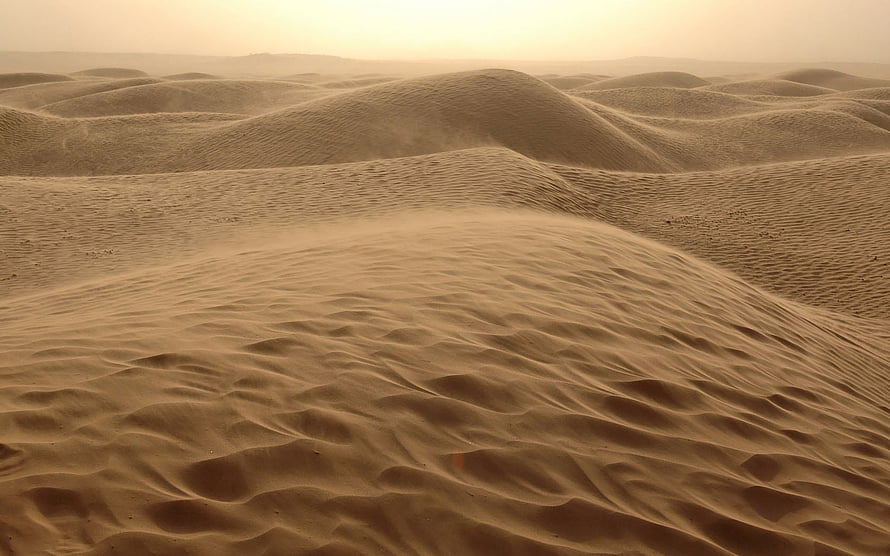 Golden Desert Dunes with Wind-Sculpted Ripples Under a Hazy Sky HD wallpaper