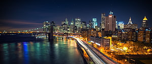 Panoramic Night View of the Manhattan Skyline with Brooklyn Bridge and East River HD wallpaper