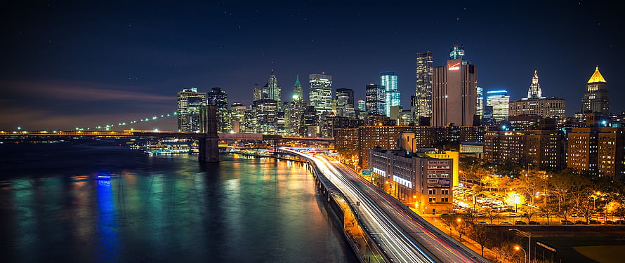 Panoramic Night View of the Manhattan Skyline with Brooklyn Bridge and East River HD wallpaper