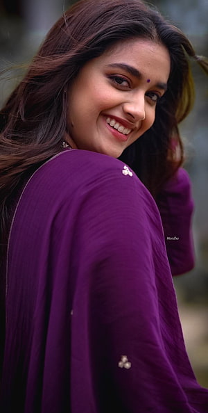 Keerthy Suresh smiling portrait in a purple traditional outfit with long dark hair HD phone wallpaper