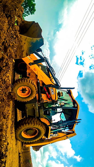 JCB Backhoe Loader Digging in Muddy Construction Site Under Blue Sky HD phone wallpaper