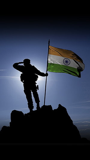 Silhouetted Soldier Saluting While Holding the Indian National Flag on a Rocky Summit HD phone wallpaper