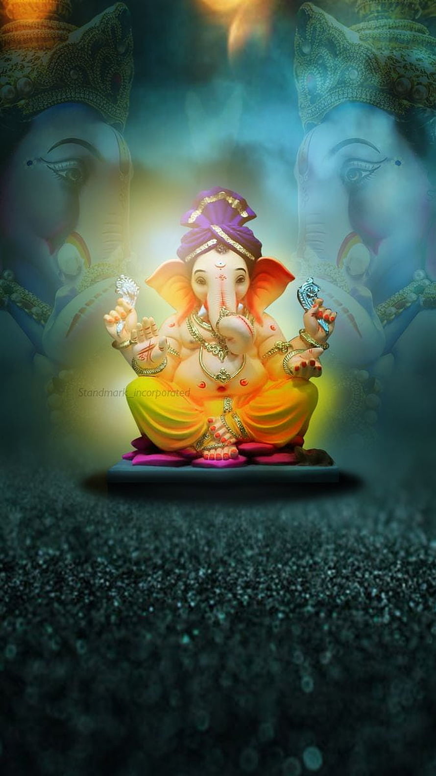 Ganesh deity statue with glowing aura and ornate jewelry on a dark textured surface HD phone wallpaper