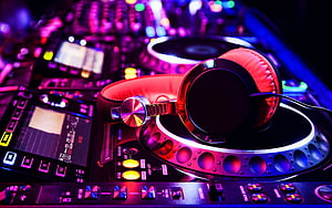Vibrant DJ Console with Headphones Under Neon Club Lighting HD wallpaper