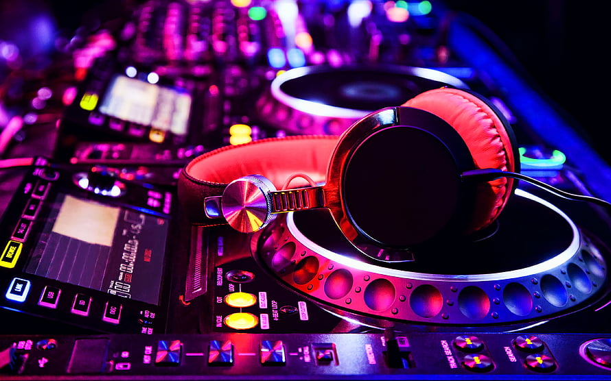 Vibrant DJ Console with Headphones Under Neon Club Lighting HD wallpaper