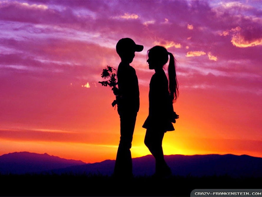 Silhouetted couple holding flowers against a vibrant sunset sky with distant mountains HD wallpaper
