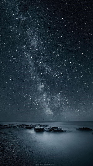 Milky Way Galaxy Over a Misty Rocky Shoreline at Night HD phone wallpaper