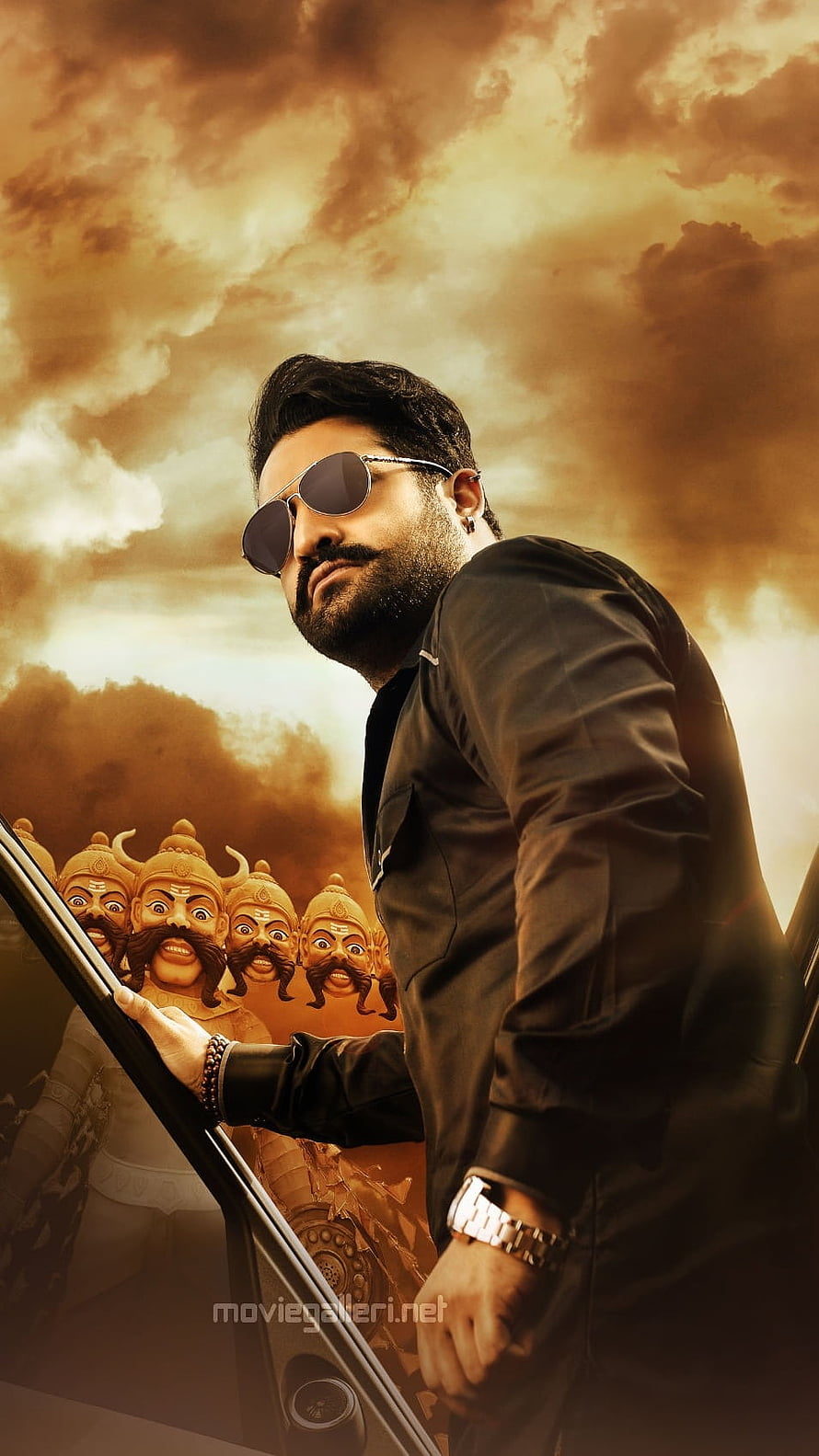 NTR in Black Suit and Sunglasses with Mythical Warriors Against Dramatic Sky HD phone wallpaper