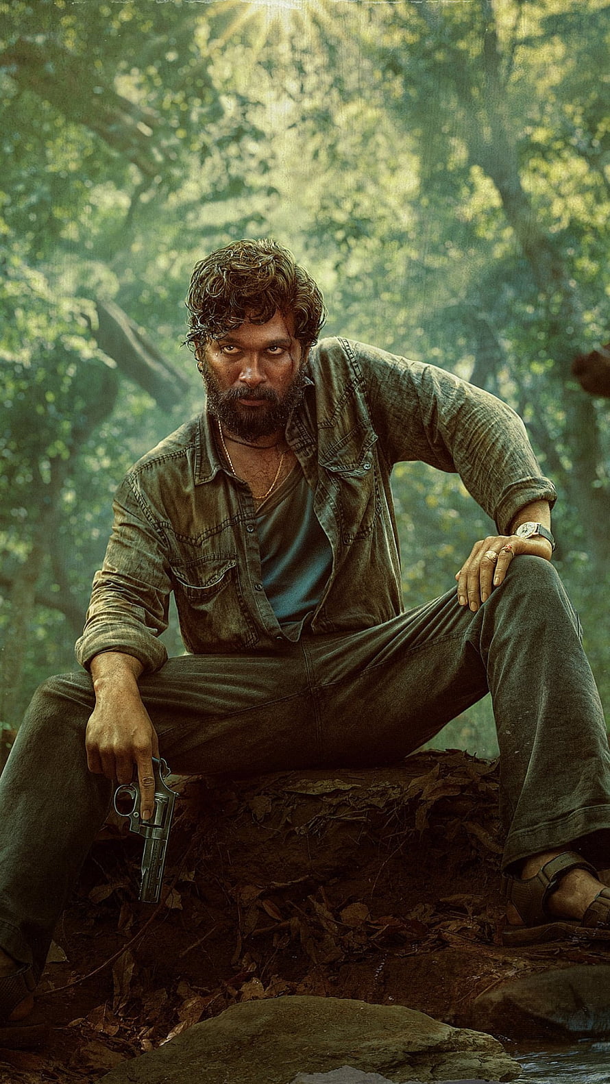 Allu Arjun as Pushpa in a gritty forest scene holding a revolver HD phone wallpaper
