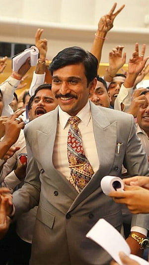 Pratik Gandhi as Harshad Mehta in a Grey Suit Amidst a Celebratory Crowd HD phone wallpaper
