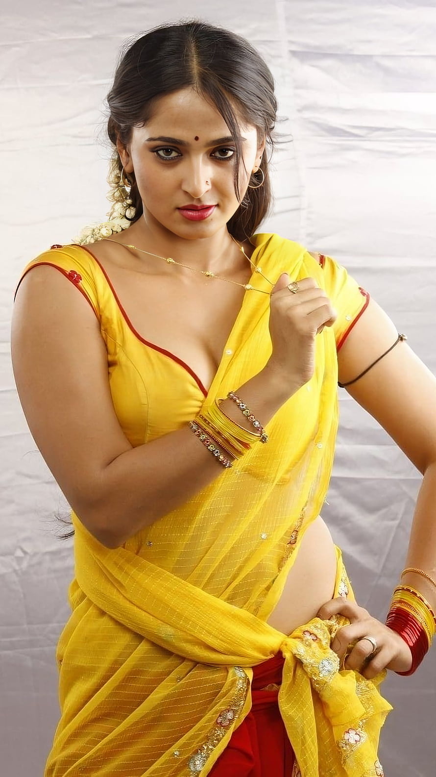 Anushka Shetty in Vibrant Yellow Saree with Traditional Gold Jewelry and Red Blouse HD phone wallpaper