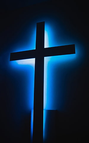 Illuminated Christian Cross Silhouette Against Deep Blue Backlit Wall HD phone wallpaper