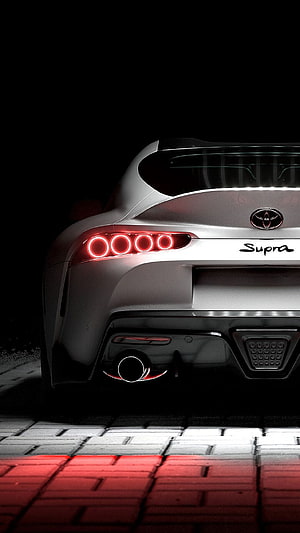 Rear View of a White Toyota Supra Mk5 with Glowing Red Taillights on a Dark Paved Surface HD phone wallpaper