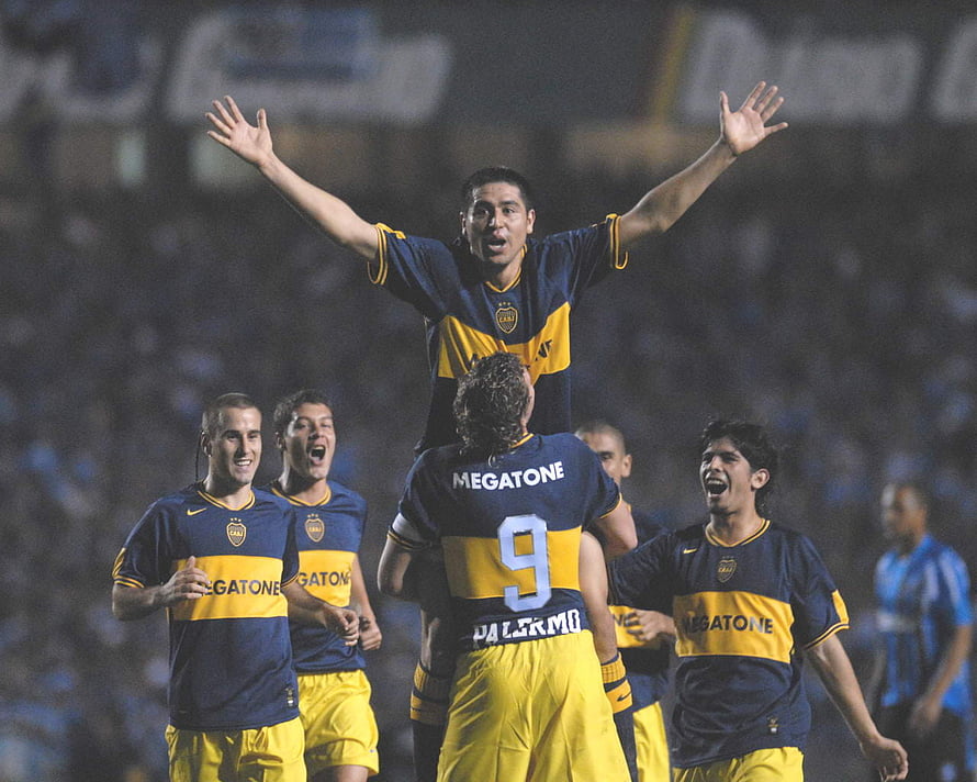Juan Roman Riquelme celebrating with Boca Juniors teammates in navy and yellow kit HD wallpaper