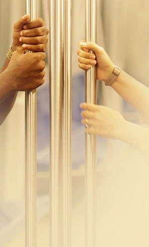 Two Pairs of Hands Gripping Vertical Metal Bars in Soft Warm Light HD phone wallpaper