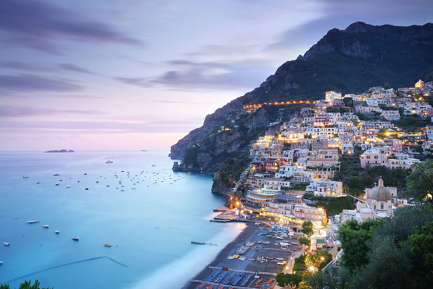 Positano Amalfi Coast Italy at Dusk with Illuminated Cliffside Buildings and Calm Sea HD wallpaper