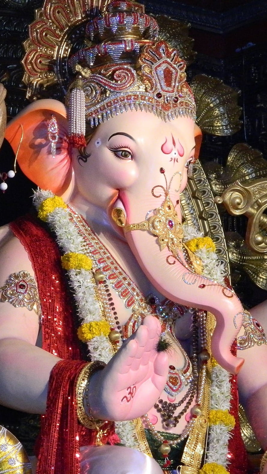 Ornate Lord Ganesha Murti Adorned With Jewels, Marigold Garlands, And Red Silk Garments HD phone wallpaper