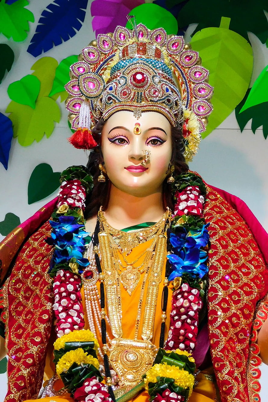 Durga Maa ornate idol adorned with gold jewelry and vibrant floral garlands HD phone wallpaper