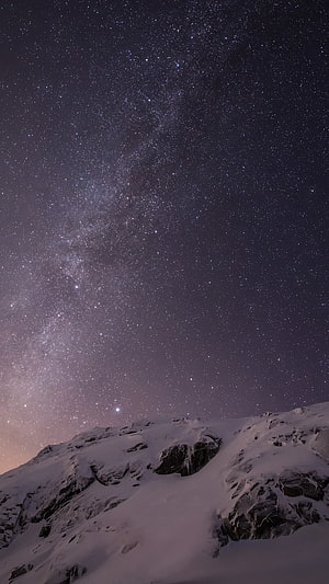 Milky Way Galaxy Rising Over Snow-Covered Mountain Peaks at Night HD phone wallpaper