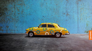 Lenovo Yellow Car with Geometric Pattern Parked Against Weathered Blue Wall HD wallpaper