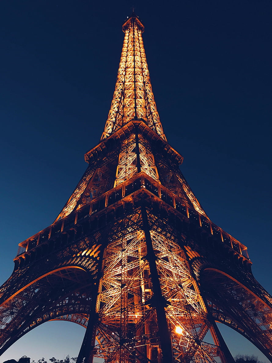 Eiffel Tower Illuminated at Night Against a Deep Blue Sky in Paris HD phone wallpaper
