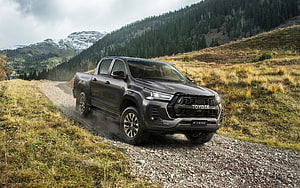 Toyota Hilux GR Sport Pickup Truck Driving on Gravel Mountain Road HD wallpaper