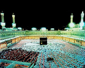 The Kaaba at Night in Mecca with Pilgrims in Prayer Circles HD wallpaper