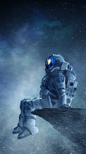 Astronaut Seated on Asteroid Edge Against Starry Nebula Background HD phone wallpaper