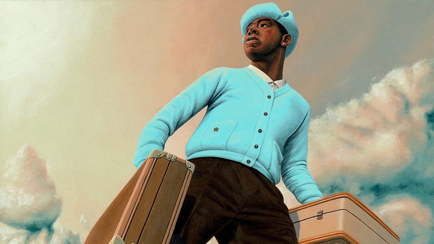 Tyler The Creator in a light blue cardigan and beret holding vintage suitcases against a dreamy pastel sky HD wallpaper
