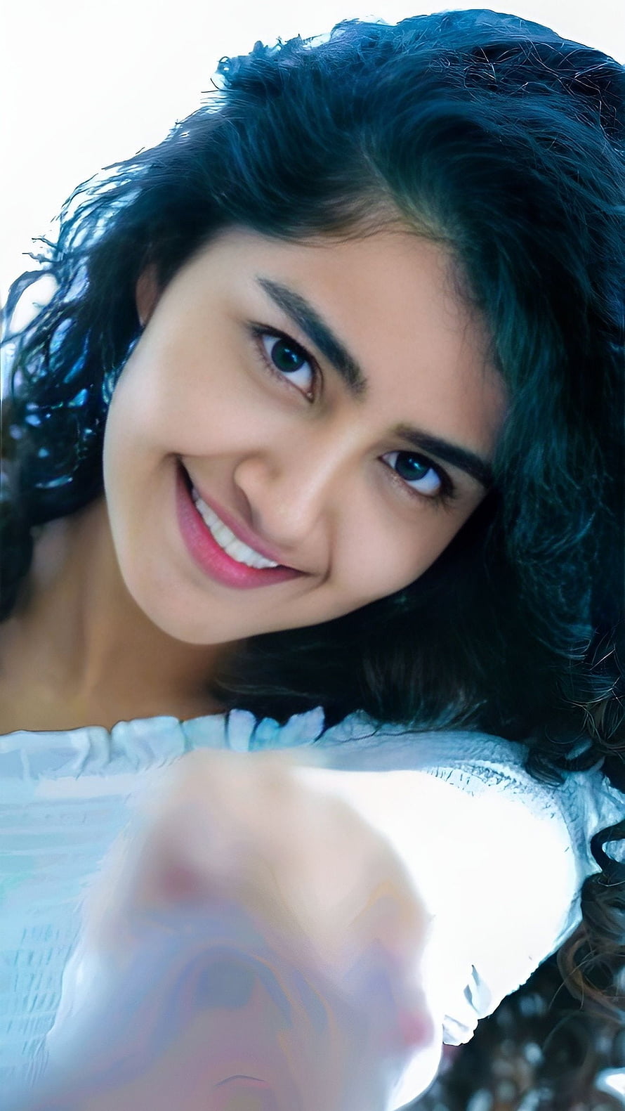 Anupama Parmeshwaran smiling close-up portrait with curly dark hair and soft natural lighting HD phone wallpaper
