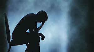 Silhouette of a Person Sitting Alone in a Dark Room Conveying Deep Sadness and Isolation HD wallpaper