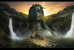 Meditating Figure Before a Giant Shiva Stone Face in a Misty Waterfall Canyon HD wallpaper