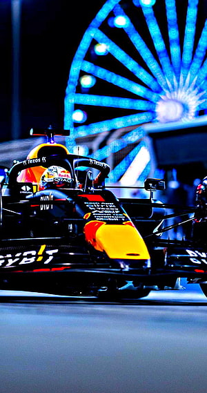 Max Verstappen Red Bull Racing Formula 1 Car at Night with Blue Ferris Wheel Background HD phone wallpaper