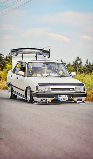 White Tofas Sedan with Large Rear Wing and Stance Setup on Country Road HD phone wallpaper