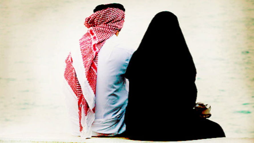 Muslim couple in traditional attire sitting together by the water HD wallpaper